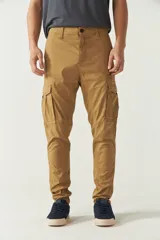 Pantalón cargo gris para hombre, de corte regular, con bolsillos laterales y traseros con solapa, pasacinto y logo metálico. Confeccionado en algodón y spandex.