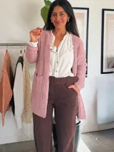 Saco tejido rosa con textura suave, corte relajado y bolsillos funcionales.