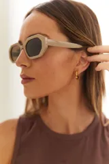 Lentes de sol con armazón de policarbonato color beige claro, de forma geométrica octogonal y cristales oscuros.