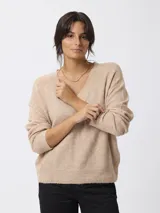 Sweater de punto con escote en V, manga larga y calce relajado. Presenta puños y cintura tejidos con terminación acanalada.