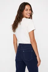 Remera blanca de manga corta con cuello redondo y estampado frontal ilustrativo de Santorini en tonos azules y naranjas.