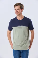 Remera de algodón y poliéster de corte clásico, con diseño en bloques de color negro en la parte superior y gris melange en la inferior. Presenta cuello redondo, mangas cortas y un pequeño estampado tipográfico en el pecho.