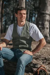 Chaleco de vestir verde oliva con textura espiga, cuello en V, cierre frontal abotonado y bolsillos ribeteados.