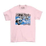 Remera de algodón color rosa con estampado gráfico frontal de la banda Turnstile, incluyendo texto y elementos artísticos en tonos azules y negros.