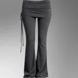 Pantalón largo negro de corte acampanado, tiro bajo, con cintura ancha drapeada y detalles de tiras colgantes en un lateral.
