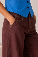 Jeans modelo Rul de corte wide leg en color bordó con efecto gastado, tiro alto y terminación desmechada en el bajo.