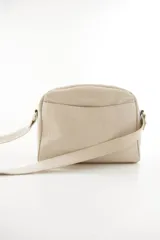 Bandolera semirrígida Sagali de cuero vacuno color bordó, con textura de cocodrilo en el bolsillo frontal y cuerpo liso. Cuenta con cierre superior y correa regulable.