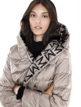 Tapado largo reversible con capucha, un lado con estampado de letras negras sobre fondo beige y otro lado liso color beige.