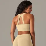 Top deportivo color beige, de tejido acanalado, con espalda deportiva y abertura en forma de gota.