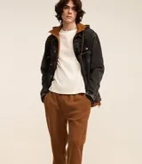 Pantalón de jogging masculino, color gris melange, confeccionado en algodón y poliéster. Presenta cintura elástica con cordón de ajuste y puños ajustados en los tobillos.