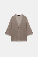 Chaqueta de punto color topo, con escote en V, mangas anchas por debajo del codo y cierre frontal de botones.