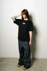 Remera negra de corte regular fit, con un pequeño parche ovalado estampado en el pecho y un gran logo de estilo manuscrito en la espalda.
