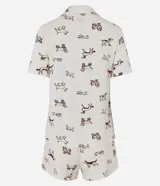 Pijama de dos piezas confeccionado en viscolycra con estampa de perros de color marrón sobre base blanca. Incluye una camisa de manga corta con solapas, cierre frontal con botones y un bolsillo en el pecho, y un short a juego con cintura elástica.
