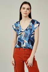 Blusa de poliéster sin mangas, con cuello en V y estampado abstracto multicolor en tonos beige, marrón, negro y naranja.