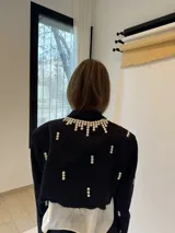 Conjunto sastre de dos piezas compuesto por un saco cropped oversized y una falda corta. El saco presenta hombreras decoradas con apliques de botones blancos y detalles de botones distribuidos en las mangas y el cuerpo. El conjunto es de color azul marino y está confeccionado mediante técnicas de upcycling sobre sastrería vintage.