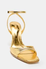 Sandalias negras de tacón fino con efecto craquelado, tira ancha en la parte delantera, cierre mediante hebilla metálica en la pulsera del tobillo y acabado en punta cuadrada.