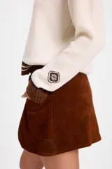 Minifalda de cuero con efecto desgastado, de silueta recta y diseño de capas frontales superpuestas. Incluye un lazo ajustable en la cintura que pasa por ojalillos metálicos y bolsillos laterales integrados.