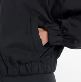 Campera bomber New Balance de color negro, con cuello clásico, cierre frontal de cremallera y bolsillos laterales. Presenta un diseño de corte holgado con puños y ruedo elásticos.