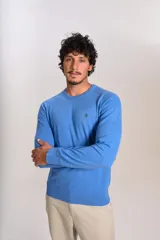 Sweater de punto de algodón en color azul, con cuello redondo, mangas largas con puños acanalados y logo de la marca bordado en el pecho.