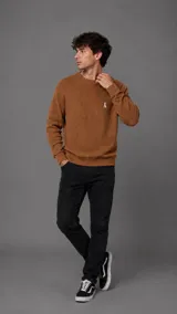 Buzo de punto color tostado con textura waffle, cuello redondo y pequeño logo bordado en el pecho.