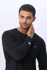 Remera básica de algodón de manga larga, color negro, con escote a la base y logo bordado en el frente.