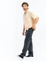 Camisa color crema de tela tetra de algodón, de corte suelto, manga corta y cuello cubano.