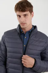 Campera puffer azul marino con cierre frontal, cuello alto y bolsillos laterales con cierre.