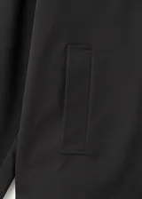 Chaqueta corta de estilo oversize en color negro, con cuello camisero, cierre frontal de botones y mangas largas con trabillas ajustables. Cuenta con dos bolsillos laterales y forro interior.