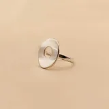 Anillo de plata 925 con diseño de doble banda que conecta un círculo plano grande con un dije circular pequeño grabado.