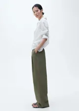 Pantalon de tiro alto con diseño wideleg, confeccionado en algodón. Presenta cierre delantero con botón, gancho y cremallera, pinzas frontales, trabillas y cinturón incorporado con hebilla metálica.