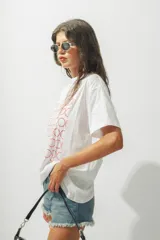 Remera de corte oversize color blanco, con cuello redondo y mangas cortas. Presenta un estampado frontal compuesto por múltiples círculos formados por puntos rojos.