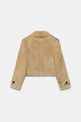 Trench corto de Zara confeccionado en piel de ante, con cuello de solapa, cierre frontal cruzado con botones, mangas largas con trabillas y bolsillos delanteros de vivo.