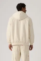 Campera tipo hoodie con cierre frontal, confeccionada en tela de algodón con diseño de rayas verticales finas. Presenta capucha con cordones ajustables, puños y ruedo acanalados, y un bolsillo tipo canguro con etiqueta decorativa.