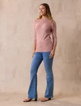 Buzo color rosa de tejido combinado con detalle de botones en las mangas y cuello redondo.