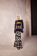 Sweater de lana tejido y bordado a mano, de color negro con diseño de figuras humanas coloridas en el frente y mangas. Presenta un calce holgado, cuello a la base y puños acanalados.