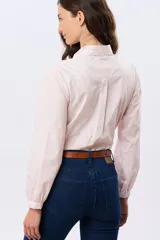 Camisa de manga larga color rosado con sutil estampado, cuello camisero, cierre frontal con botones y frunces en los puños.