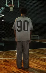 Remera de manga corta y cuello redondo, calce oversize, color marrón oscuro con efecto batik/lavado. Presenta un pequeño bordado o aplique con la palabra "RAVERS" en el pecho.