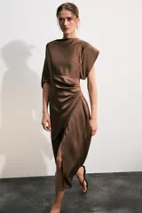Vestido midi de satén color marrón, con cuello redondo, manga corta con capa fluida y cintura entallada con pliegues. Cuenta con falda recta con abertura en el bajo y cierre lateral con cremallera oculta.