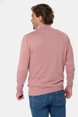 Buzo de tejido fino en hilo de algodón, color rosado, con cuello alto y cierre frontal parcial con detalle en cuero. Presenta puños y ruedo acanalados y un pequeño logo bordado en el pecho.