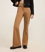 Pantalón de mujer modelo flare, confeccionado en punto roma color marrón, con cintura alta, bolsillos delanteros de solapa, bolsillos traseros embutidos y cierre delantero con cremallera.