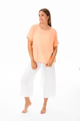 Blusa color coral claro de viscosa con escote redondo y mangas cortas con dobladillo.