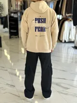 Canguro oversize de color beige con capucha y estampado en la espalda que dice "PUSH Through FEAR".