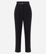 Pantalón carrot negro de sastrería, con bolsillos, pliegues y cinturón fino de cuero sintético.