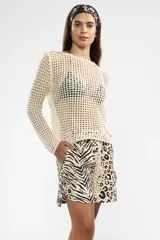 Sweater de tejido calado color crema, de manga larga y con cuello bote.