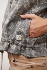 Bomber de tela liviana color beige con textura sutil, cierre frontal completo, mangas largas con puños elásticos y cordón ajustable en el ruedo.