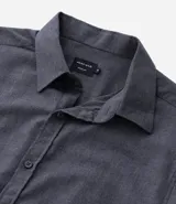 Camisa de manga larga confeccionada en tricolina de algodón, con cuello inglés, cierre frontal de botones y puños abotonados. Diseño liso y versátil.