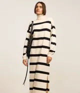 Vestido midi de punto con cuello alto y mangas largas. Diseño recto con rayas horizontales negras sobre fondo crudo y aberturas laterales.