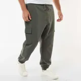 Pantalón cargo color verde militar, con bolsillos laterales tipo cargo, cintura elástica y puños ajustados en los tobillos.