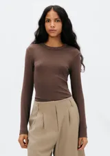 Camiseta básica de manga larga en tela acanalada color marrón, con cuello redondo.