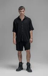 Camisa de manga corta con cuello solapa, confeccionada en lino. Presenta un corte oversize y cierre frontal con botones.